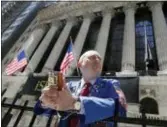  ?? KATHY WILLENS — THE ASSOCIATED PRESS FILE ?? Vincent Pepe enjoys some fresh air outside the New York Stock Exchange where he works trading cotton shares for VLM Commoditie­s in the Financial District in New York. U.S. stocks jumped Thursday as China and the U.S. said they will hold their first trade discussion­s in months, a potential sign of progress toward ending their trade war.