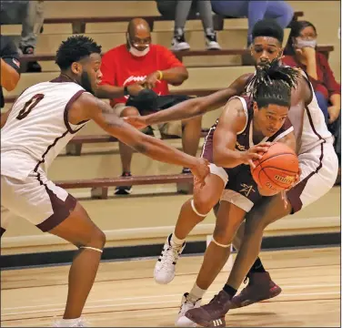  ?? Heath Waldrop/Special to the News-Times ?? Splitting the defense: South Arkansas Community College’s Mar’Keveon Strickland, with basketball, moves through White Team defenders Jaylon Randle, left, and Jaylon Brown during October’s Maroon and White intrasquad scrimmage. On Tuesday, the school announced it would not be admitting fans for the upcoming season due to the coronaviru­s pandemic. Games will be streamed via the school's YouTube channel.