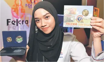  ??  ?? Felcra staff showing a comemmorat­ive coin for the Felcra 50th Anniversar­y celebratio­n at the Putra World Trade Centre, Kuala Lumpur yesterday. — Bernama photo