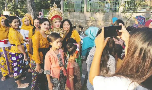  ?? PHOTOS: BEH LIH YI/THOMSON REUTERS FOUNDATION ?? A bride is photograph­ed during a wedding procession in Lombok, Indonesia. The country has raised the marriage age for girls to 19 from 16.