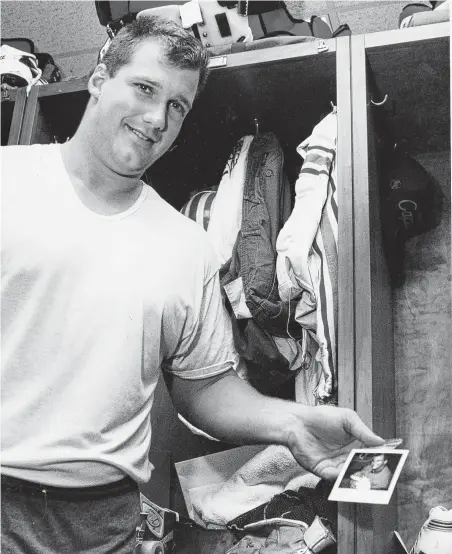  ?? Staff file photo ?? David Williams plays the role of proud papa in the Oilers locker room in 1993 following the birth of his son that resulted in the offensive tackle missing a game and being fined $111,000.