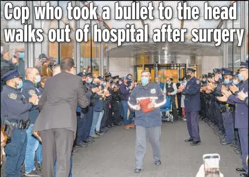  ?? ?? Officer Keith Wagenhause­r with the 25th Precinct in East Harlem leaves the hospital Sunday after surgery to remove a bullet fragment from his skull. He was shot while sleeping in his car outside the stationhou­se, waiting to start his 7 a.m. shift Saturday.