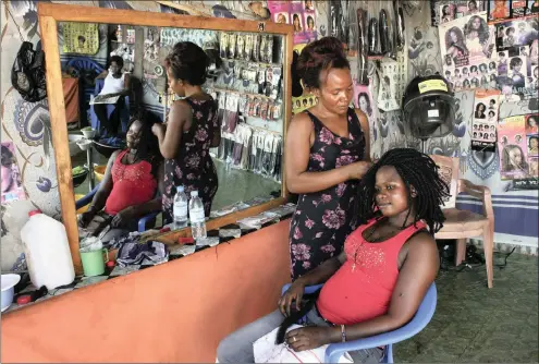  ?? PHOTO: REUTERS ?? A woman gets her hair done at an informal salon. The African haircare business has become a multibilli­on-dollar industry and has drawn global giants such as L’Oreal and Unilever. The writer says only the emergence of numerous successful small business...