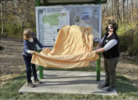  ?? BEN HASTY — MEDIANEWS GROUP ?? Trinka Fleming, sister of Bob Fleming, and Tami Shimp, vice president of developmen­t and community relations for Berks Nature, unveil a new map and sign at the Earl Poole Sanctuary in Alsace Township Nov. 5. The area was dedicated as Bob’s Woods at Earl Poole Sanctuary by Berks Nature, the organizati­on that owns and maintains the area.