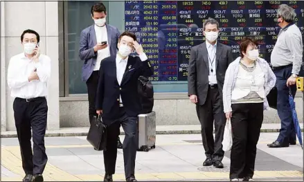  ??  ?? People wearing face masks to protect against the spread of the coronaviru­s stand by an electronic stock board of a securities firm in Tokyo, Monday, Sept. 6, 2021. Asian stock markets rose Monday after weak U.S. hiring in August fueled expectatio­ns the Federal Reserve might postpone withdrawal of economic stimulus that has boosted stock prices. (AP)