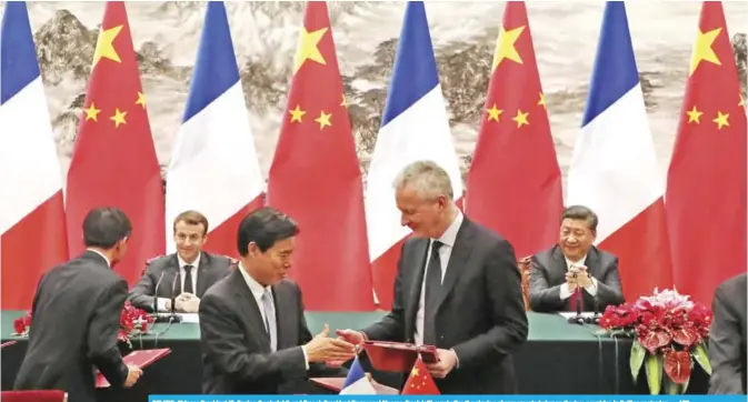  ??  ?? BEIJING: Chinese President Xi Jinping (back right) and French President Emmanuel Macron (back left) react after the signing of agreements between the two countries in Beijing yesterday. — AFP