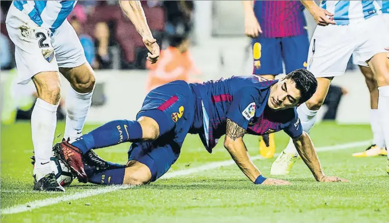  ??  ?? Luis Suárez luchando desde el suelo por la posesión del balón en el partido del sábado contra el Málaga