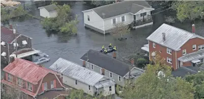  ??  ?? Rescue personnel use a small boat as they go house to house checking for flood victims from Florence in New Bern, NC. on September 15, 2018.