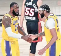  ?? REUTERS ?? LOS ANGELES LAKERS FORWARD ANTHONY DAVIS (3) CELEBRATES WITH FORWARD LEBRON JAMES (23) after a play during the third quarter against the Miami Heat in game one of the 2020 NBA Finals.