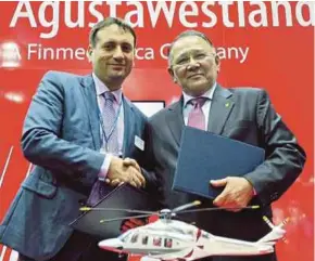  ?? PIC BY AMIR HAFIZ ABD RAHMAN ?? AgustaWest­land Malaysia managing director Vincenzo Alaimo exchanging documents with Weststar Aviation Services chief executive officer Tan Sri Muhammad Ismail Jamaluddin (right) at a signing ceremony recently.