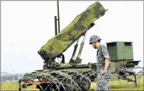  ?? AP/EUGENE HOSHIKO ?? A Japanese soldier helps set up a PAC-3 missile-defense system today at Yokota Air Base on the outskirts of Tokyo in an already planned training exercise that followed North Korea’s launch of a ballistic missile that soared over northern Japan....