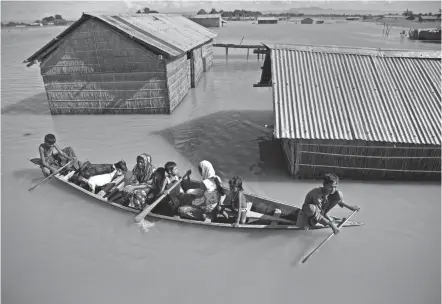  ?? ANUPAM NATH/AP FILE ?? A family in northeaste­rn Assam state, India, travels by boat amid floodwater­s in 2016. A World Bank report looks at how climate change could create “climate migrants.”