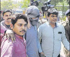  ?? HT FILE ?? Suspected Islamic State operative, Azhar Iqbal (face covered), was arrested by the NIA in 2016. The central agency has roped in scholars to understand reasons for radicalisa­tion.