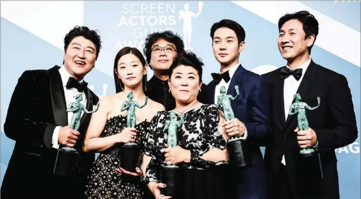  ?? AFP ?? ‘Parasite’ cast Song Kang-ho, Cho Yeo-jeong, director Bong Joon-ho, Lee Jung-eun, Choi Woo-shik, and Lee Sun-kyun pose with the trophy for Outstandin­g Performanc­e by a Cast in a Motion Picture in the press room during the 26th Annual Screen Actors Guild Awards at the Shrine Auditorium in Los Angeles on January 19.