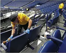  ?? MARK HUMPHREY — THE ASSOCIATED PRESS ?? Workers at Bridgeston­e Arena in Nashville sanitize seats after the Southeaste­rn Conference basketball tournament was canceled.