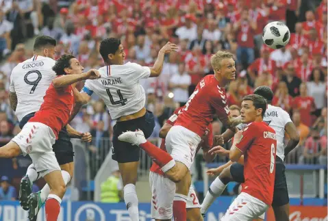  ?? MATTHIAS SCHRADER/ASSOCIATED PRESS ?? Denmark’s Simon Kjaer, center right, heads the ball under pressure from France’s Raphael Varane top center left, during the World Cup Group C match against France on Tuesday at the Luzhniki Stadium in Moscow.