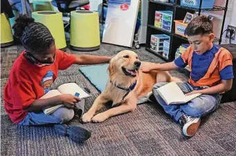  ?? Courtesy Cypress-Fairbanks Independen­t School District ?? Third-graders Shane Rogers, left, and Nathan Espinoza read to Skye, the first full-time campus comfort dog in Texas, in October at Walker Elementary School in Katy.