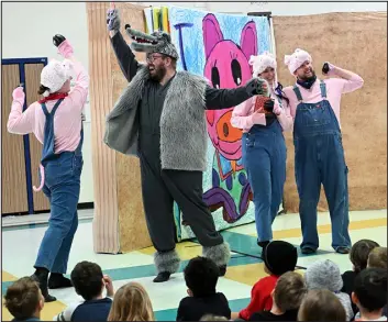  ?? JENNY SPARKS — REPORTER- HERALD ?? The three little pigs, played by Katie Harper- Griffith, left, Kelsie Furst and Nathan Snyder, right, and the wolf, played by Colin Williamson, perform Thursday the Loveland Opera Theatre’s production of “Three Little Pigs” for students at Namaqua Elementary School in Loveland.
