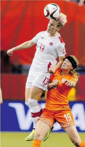  ?? MINAS PANAGIOTAK­IS/GETTY IMAGES ?? Sophie Schmidt jumps for the ball as Kirsten Van De Ven of the Netherland­s challenges during the Group A match at Olympic Stadium on June 15 in Montreal. Schmidt went down hard in that game and has been nursing a sore hip all week.