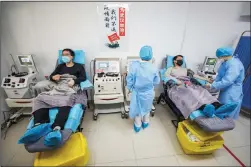  ?? STR/AFP/GETTY IMAGES ?? Doctors who have recovered from the COVID-19 coronaviru­s infection donate plasma on Feb. 18 in Wuhan in China’s central Hubei province.