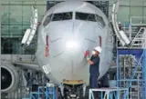  ?? REUTERS ?? A worker cleans a Boeing 737-800 plane in Garuda Maintenanc­e Facility Aero Asia hangar at Soekarno-Hatta airport near Jakarta, Indonesia.