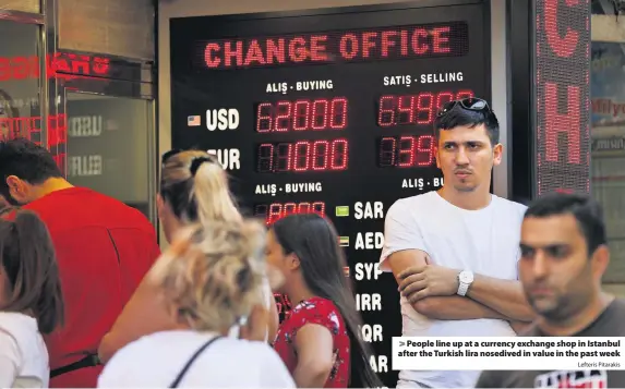  ?? Lefteris Pitarakis ?? &gt; People line up at a currency exchange shop in Istanbul after the Turkish lira nosedived in value in the past week