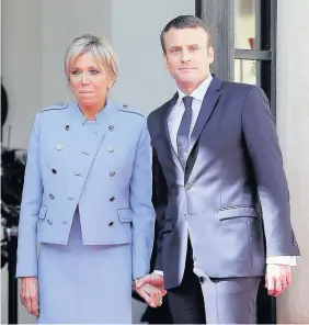  ??  ?? > President Emmanuel Macron and his wife Brigitte Trogneux pose on the steps of the Elysee Palace after the handover ceremony with France’s outgoing President Francois Hollande yesterday