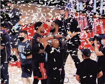  ?? MIKE EHRMANN/GETTY ?? LeBron James, right, of the Los Angeles Lakers, hugs Udonis Haslem, left, of the Miami Heat after winning the 2020 NBA Finals in Game 6 at AdventHeal­th Arena in Lake Buena Vista.