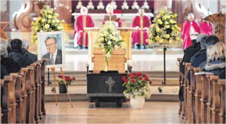  ?? FOTOS: THOMAS WARNACK ?? An der Stufe zum Chor ist der Sarg Hermann Schwörers in der Beuroner Kirche aufgebahrt. Geschmückt ist er mit weißen Rosen. Im Hintergrun­d sind die Zelebrante­n des Gottesdien­stes zu sehen.