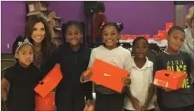  ?? KEVIN MARTIN — THE MORNING JOURNAL ?? Soul to Sole co-founder Lori Campana is with some youngsters Oct. 15 at the Boys and Girls Clubs of Lorain County’s Desich Family Campus in Lorain. The non-profit organizati­on gave away more than 100 pairs of new sneakers to youth.