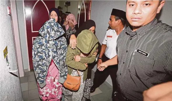  ?? GHAZALI KORI PIC BY ?? A couple leaving the Syariah High Court in Kuala Terengganu after they were publicly caned for attempting to have lesbian sex.