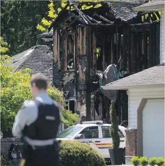  ?? DARRYL DYCK/THE CANADIAN PRESS ?? A Mountie stands near a burned-out home during an investigat­ion of multiple homicides in Rosedale, B.C., Friday.