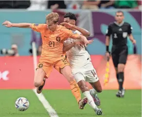  ?? LEE JIN-MAN/AP ?? Frankie de Jong of the Netherland­s, left, and Qatar’s Homam Ahmed fight for the ball during a World Cup group A match Tuesday at the Al Bayt Stadium in Al Khor, Qatar.