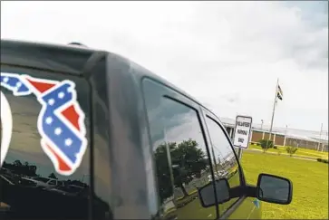  ?? David Goldman Associated Press ?? A TRUCK with a Confederat­e flag-themed decal is parked outside a state prison facility in Lake Butler, Fla. For decades the state has grappled with the issue of prison guards who are part of white supremacis­t groups.