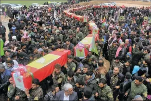  ?? The Associated Press ?? SYRIA: This photo provided by Hawar News Agency, a Kurdish-run news agency, which has been authentica­ted based on its contents and other AP reporting, shows fighters from the predominan­tly-Kurdish Syrian Democratic Forces carrying the coffins of their...