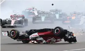  ?? Molly Darlington/Reuters ?? Zhou Guanyu’s Alfa Romeo flips over before slamming into the barriers. Photograph: