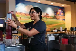  ?? The Associated Press ?? ■ Karen Rosa, a bartender who was newly hired this year, works the bar on Aug. 27 at the Lost Dog Cafe, in Fairfax, Va. Lost Dog is one of a growing number of companies that, in a desperatio­n for hired hands, is loosening restrictio­ns on everything from age to level of experience.