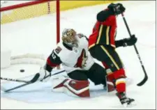  ?? ROSS D. FRANKLIN — THE ASSOCIATED PRESS ?? Flames center Mark Jankowski, right, scores a shorthande­d goal against Coyotes goaltender Antti Raanta during the third period Sunday in Glendale, Ariz. The Flames defeated the Coyotes 6-1.