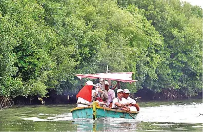  ?? DIKA KAWENGIAN/JAWA POS ?? PENYIMPAN KARBON: Pengunjung menikmati daerah ekowisata mangrove Pamurbaya yang menyimpan karbon 8.064,39 ton per hektare.