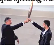  ?? PHOTO: REUTERS ?? President of the Hellenic Olympic Committee Spyros Capralos (left) and Tony Estanguet, president of 2024 Paris Olympics organising committee hold the olympic flame