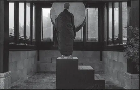  ?? The New York Times/GILLES SABRIE ?? A nun beats a drum to announce the beginning of morning classes at the Temple of Great Awakening, built by the Fo Guang Shan Buddhist movement in Yixing, China. While the Chinese government tightens its control over other foreign religious...