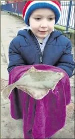  ??  ?? A young angler shows off his catch