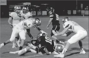  ?? MARK HUMPHREY ENTERPRISE-LEADER ?? A Shiloh Christian defender reaches down to unlatch the helmet of Prairie Grove quarterbac­k J.D. Elder after a 5-yard run. He was flagged for a 15-yard personal foul penalty and Elder stayed in the game, throwing a 30-yard touchdown pass to Stone...