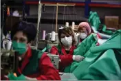  ?? ALVARO BARRIENTOS — THE ASSOCIATED PRESS ?? Volunteer workers in a clothing factory make hospital gowns for medical staff in Arnedo, Spain, on Monday.
