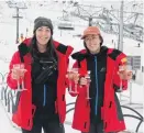  ??  ?? Toasty . . . Remarkable­s staff Kendra Stronach (left) and Alex Laframbois­e enjoy a drink on the ski resort’s opening day on Saturday.
