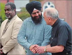  ?? DANA JENSEN/THE DAY ?? Swaranjit Singh Khalsa, center, of the Sikh Sewak Society Internatio­nal, USA and Father Ray Introvigne, right, co-director of Spiritual Renewal Services in Norwich, shake hands as they join Rev. Gregory Perry, left, of the Greenville Congregati­onal...