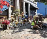  ?? BONNIE MEIBERS / STAFF ?? Annette Gibson-Strong sits in front of a memorial for victims of the Oregon District mass shooting, vowing not to let anyone move it.