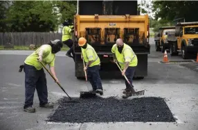  ??  ?? Allentown street workers patch a hole near Jordan Park.