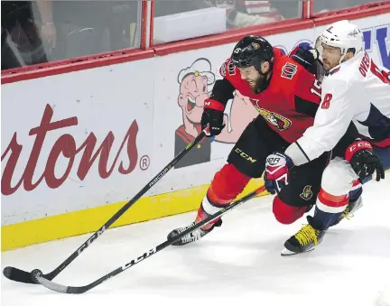  ?? ADRIAN WYLD/THE CANADIAN PRESS ?? Senators left-winger Zack Smith and Washington Capitals superstar Alex Ovechkin battle for the puck during the second period in Ottawa on Thursday. Ovechkin scored three goals in the third period to fuel a Washington comeback before they won 5-4 in a...