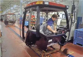  ?? MILWAUKEE JOURNAL SENTINEL FILES ?? Butch Ruffalo, cab tester at the Case New Holland plant in Racine, checks electronic­s on a Case IH MX Magnum cab on the line of the new tractor production facility in 2002 in Racine.